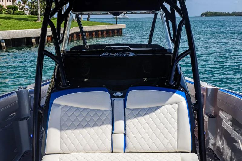 Knotty G Yacht Photos Pics 2020 Nor-Tech 340 boat interior with white quilted seats and blue accents, near water.