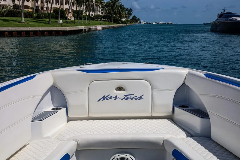 Knotty G Yacht Photos Pics 2020 Nor-Tech 340 boat interior with waterfront view, featuring white and blue seating.