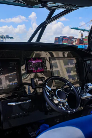 Knotty G Yacht Photos Pics 2020 Nor-Tech 340 boat dashboard with modern controls and steering wheel, under a clear blue sky.