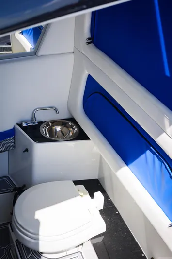 Knotty G Yacht Photos Pics 2020 Nor-Tech 340 boat interior with toilet and sink, featuring blue accents.