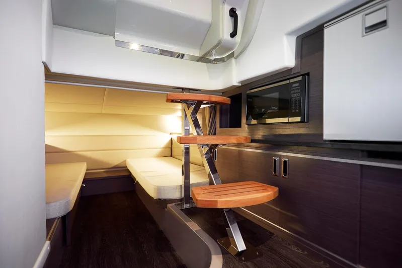  Yacht Photos Pics 2025 Sea Ray Sundancer 320 cabin interior with wooden steps, modern kitchenette, and cozy seating area.