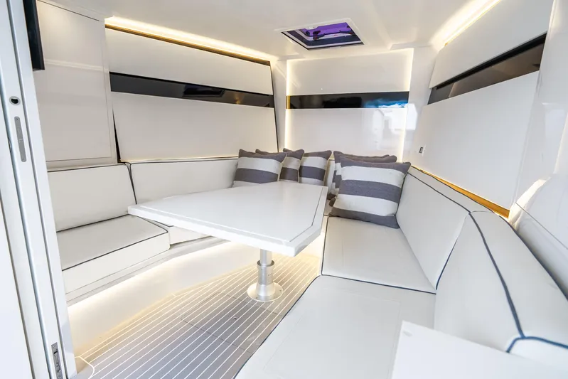 Brix Yacht Photos Pics Luxurious interior of 2023 VanDutch 48 yacht with sleek white seating and striped cushions.