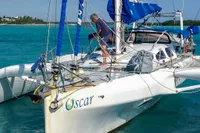 Custom Trimaran Polynésie 42 sailing in turquoise waters, 2008 model, with a person on deck.