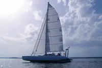 Custom Trimaran Polynésie 42 sailing on calm waters under a cloudy sky, 2008 model.