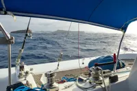 Trimaran Polynésie 42 sailing on open sea, view from cockpit, under blue canopy, 2008 model.