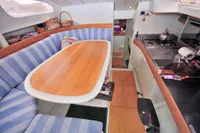 Interior of 2008 Custom Trimaran Polynésie 42 with cozy dining area and compact kitchen.