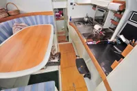 Interior of 2008 Custom Trimaran Polynésie 42, featuring kitchen and dining area with wood accents.