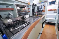 Interior of 2008 Custom Trimaran Polynésie 42, featuring a compact kitchen with stove and oven.