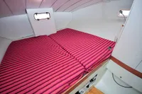Cozy cabin interior of 2008 Custom Trimaran Polynésie 42 with striped bedding.