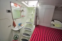 Interior of 2008 Custom Trimaran Polynésie 42 with modern design and striped bedding.