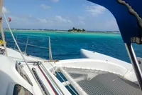 Trimaran Polynésie 42 sailing near tropical island, turquoise waters, clear sky, 2008 model.