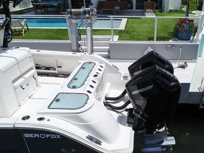  Yacht Photos Pics 2024 Sea Fox 328 Commander boat with dual Mercury engines docked by a poolside.