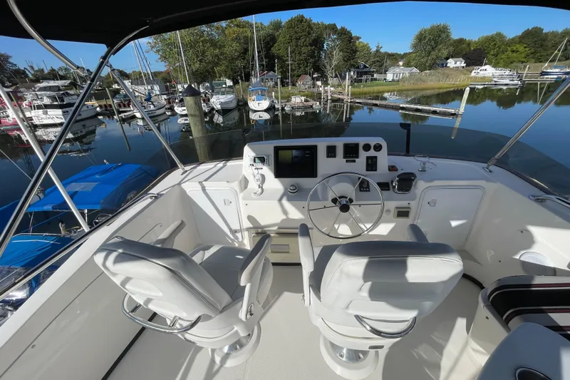  Yacht Photos Pics Flybridge of 2015 Nordic Tug 39, featuring dual captain chairs and marina view.