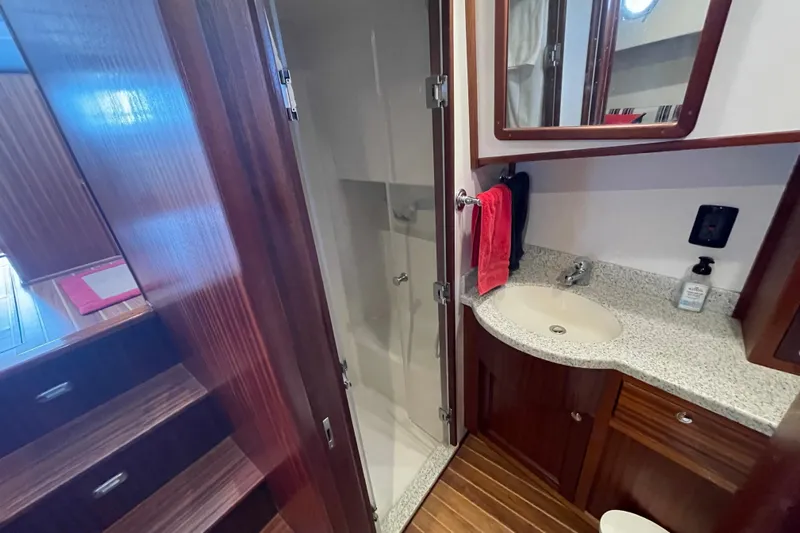  Yacht Photos Pics 2015 Nordic Tug 39 bathroom with wood accents, shower, and granite countertop.