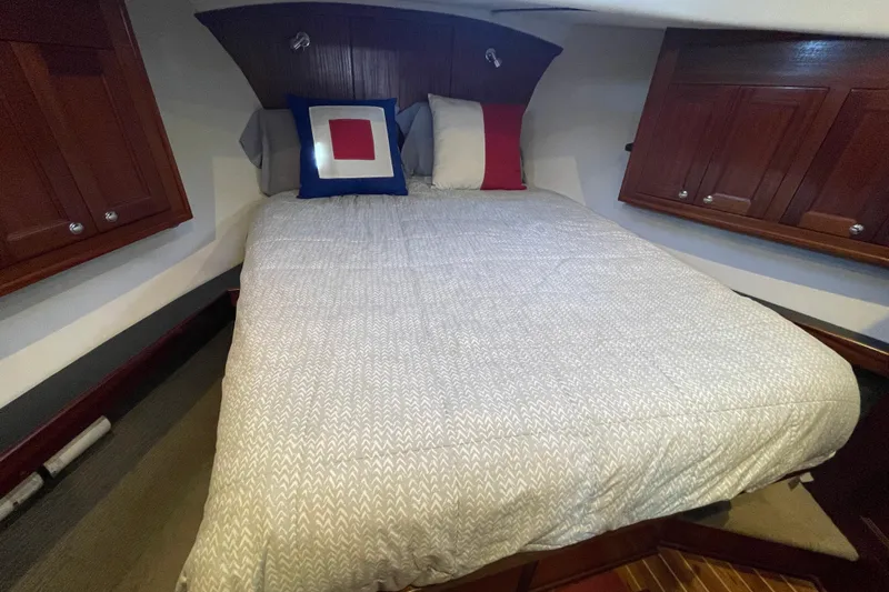  Yacht Photos Pics Cozy bedroom in 2015 Nordic Tug 39 with wooden cabinets and decorative pillows.