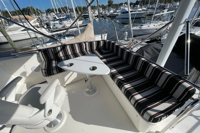  Yacht Photos Pics Flybridge seating area on 2015 Nordic Tug 39, featuring striped cushions and a triangular table.