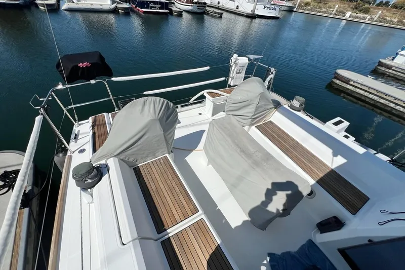 Toofun Yacht Photos Pics 2016 Beneteau Oceanis 38 sailboat deck with covered seating, docked in marina.