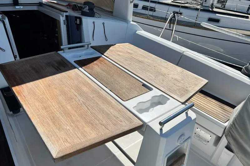 Toofun Yacht Photos Pics Cockpit of 2016 Beneteau Oceanis 38 sailboat with wooden table and seating.