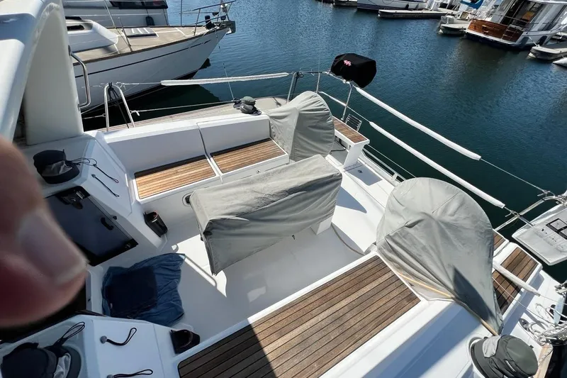Toofun Yacht Photos Pics 2016 Beneteau Oceanis 38 sailboat deck with covered seating in marina.