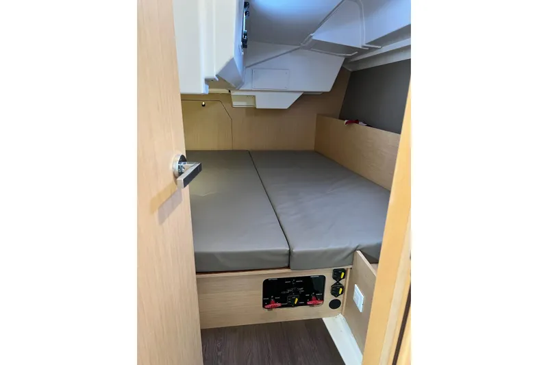 Toofun Yacht Photos Pics 2016 Beneteau Oceanis 38 cabin interior with bed and control panel.