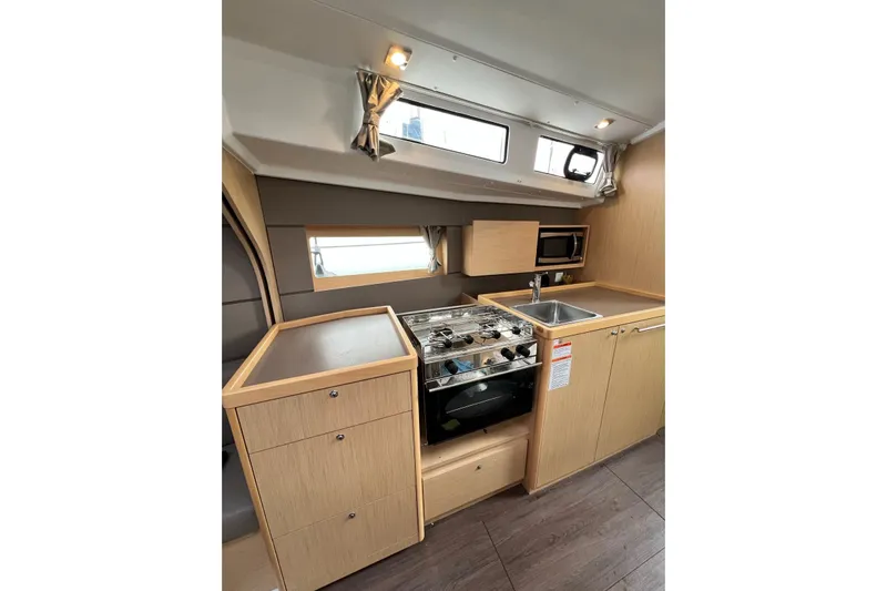 Toofun Yacht Photos Pics Interior of 2016 Beneteau Oceanis 38 yacht kitchen with stove, sink, and cabinets.