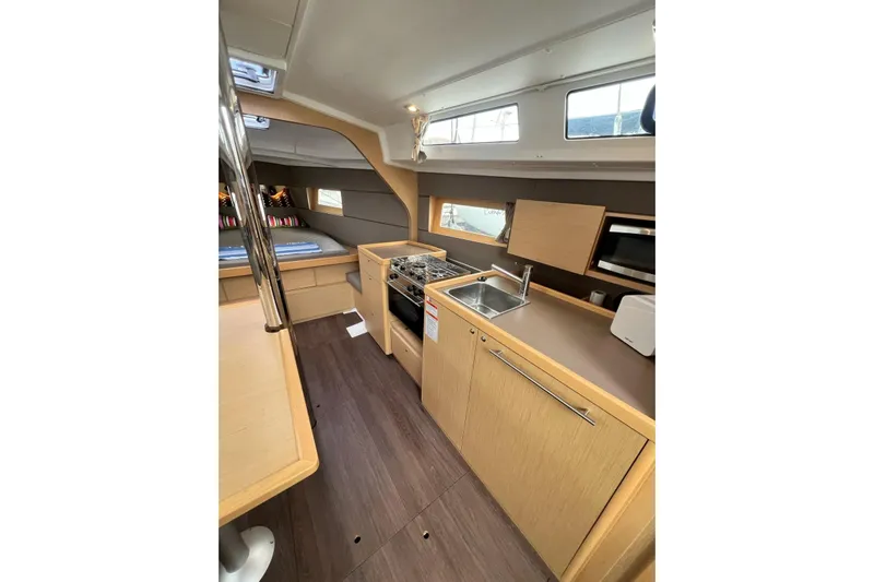 Toofun Yacht Photos Pics Interior of 2016 Beneteau Oceanis 38 yacht, featuring modern kitchen and cozy sleeping area.