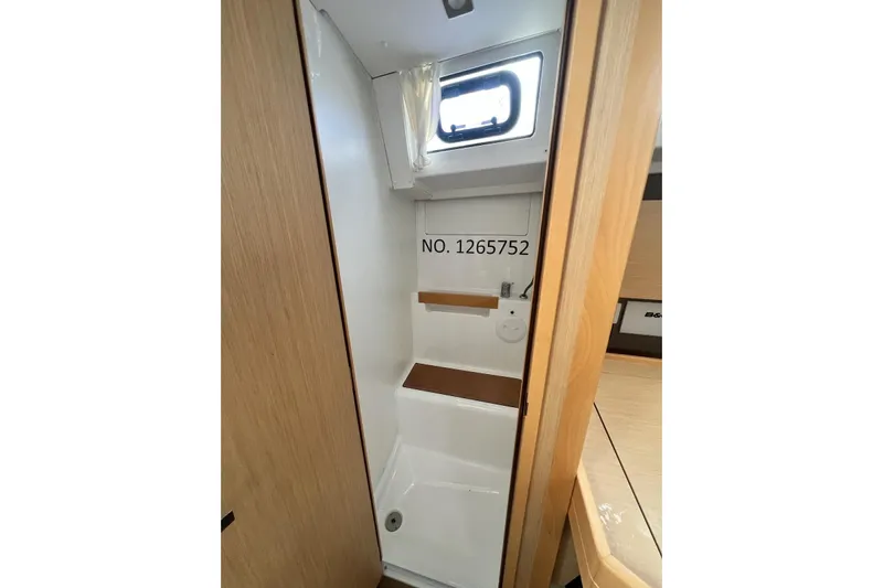 Toofun Yacht Photos Pics Interior of 2016 Beneteau Oceanis 38 yacht bathroom with wooden accents and window.