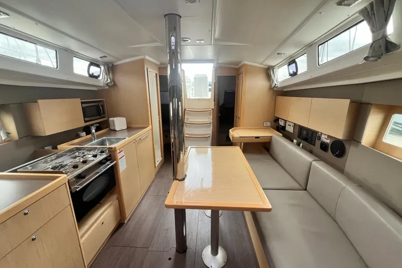 Toofun Yacht Photos Pics Interior of 2016 Beneteau Oceanis 38 sailboat with modern kitchen and seating area.