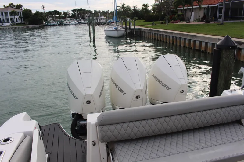  Yacht Photos Pics 2020 Boston Whaler 350 Outrage with triple Mercury engines docked by waterfront homes.