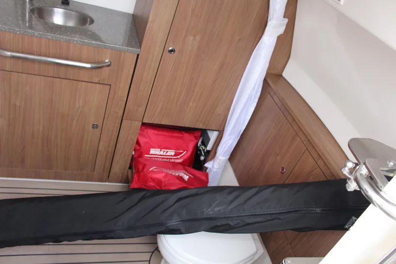  Yacht Photos Pics 2020 Boston Whaler 350 Outrage interior with sink, storage, and red safety gear.