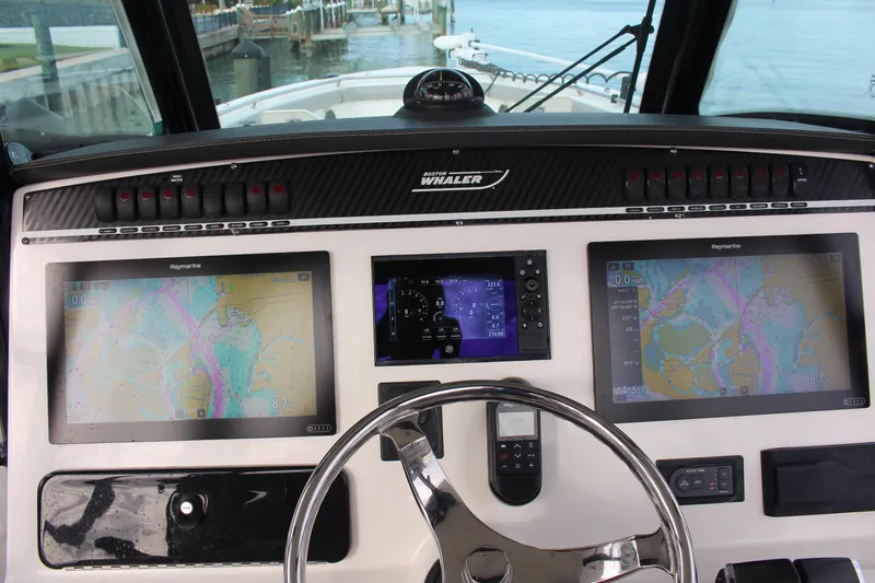  Yacht Photos Pics Control panel of 2020 Boston Whaler 350 Outrage with navigation screens and steering wheel.