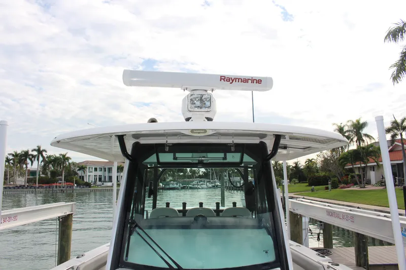  Yacht Photos Pics 2020 Boston Whaler 350 Outrage docked, featuring Raymarine equipment, with waterfront homes in the background.