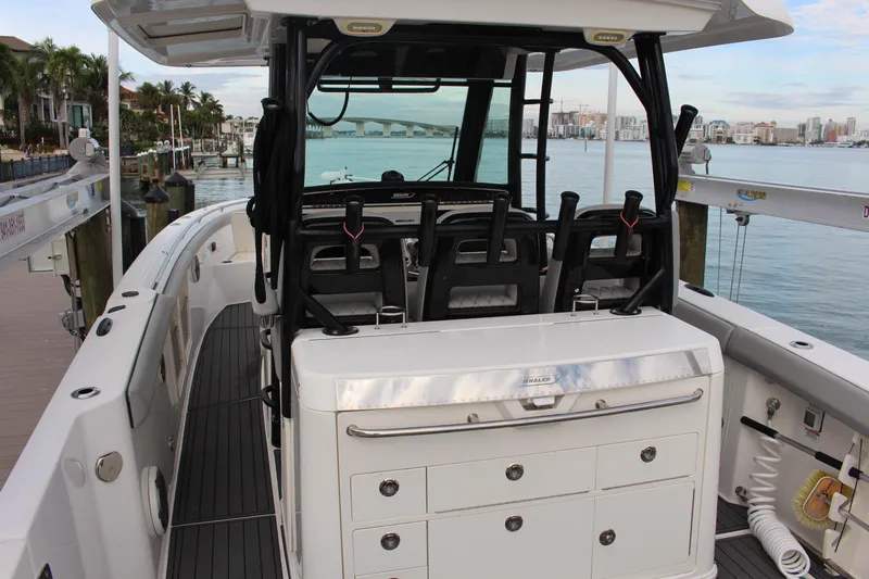 Yacht Photos Pics 2020 Boston Whaler 350 Outrage boat interior with seating and storage, docked by the water.