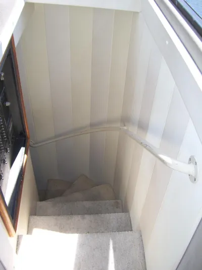  Yacht Photos Pics Staircase inside 1999 Bayliner 5788 Pilot House Motoryacht with white paneling and carpeted steps.