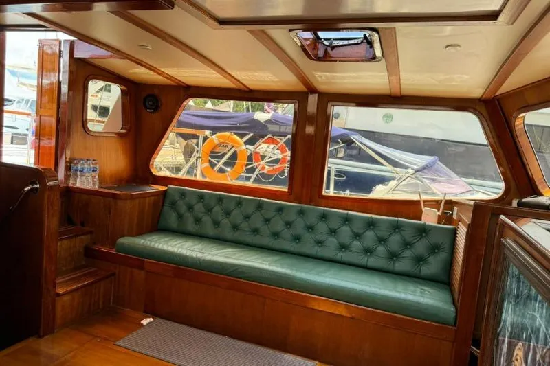  Yacht Photos Pics Interior of 1987 Don Brooke 77 yacht with green leather seating and wooden finish.