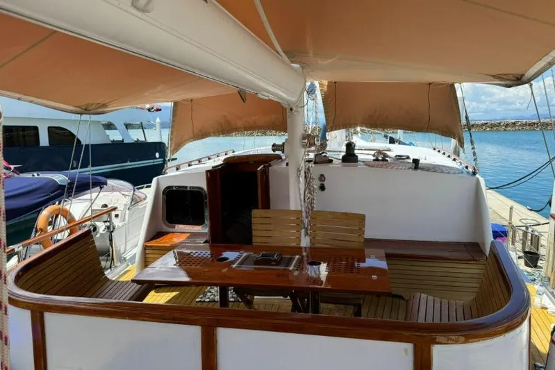  Yacht Photos Pics 1987 Don Brooke 77 yacht deck with seating and canopy, docked at marina.