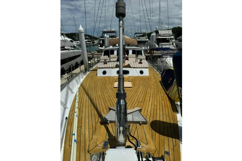  Yacht Photos Pics Deck view of 1987 Don Brooke 77 yacht, featuring wooden finish and marina background.