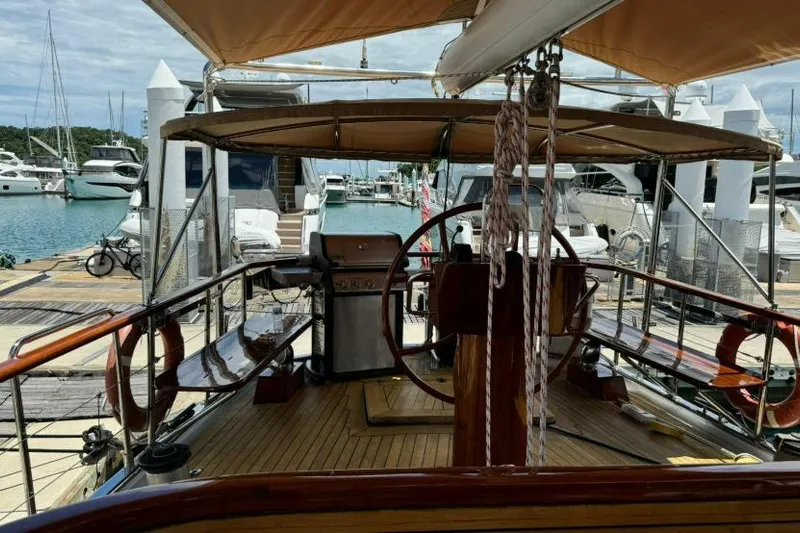  Yacht Photos Pics Vintage 1987 Don Brooke 77 yacht docked at marina, featuring wooden deck and helm.
