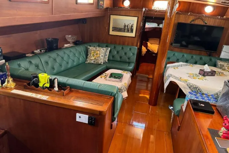 Yacht Photos Pics Luxurious 1987 Don Brooke 77 yacht interior with green leather seating and elegant wood finishes.