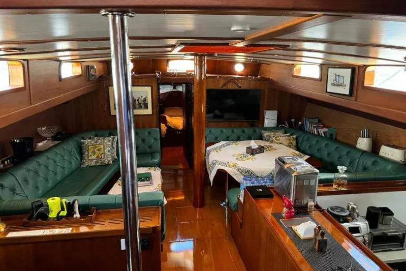  Yacht Photos Pics Luxurious 1987 Don Brooke 77 yacht interior with green seating, dining area, and kitchen amenities.