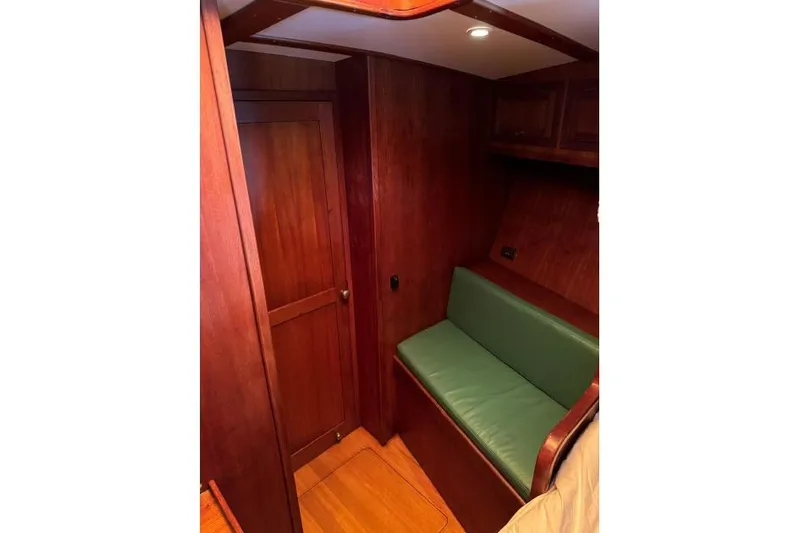  Yacht Photos Pics Wood-paneled cabin interior with green cushioned seating, Don Brooke 77, 1987 model.