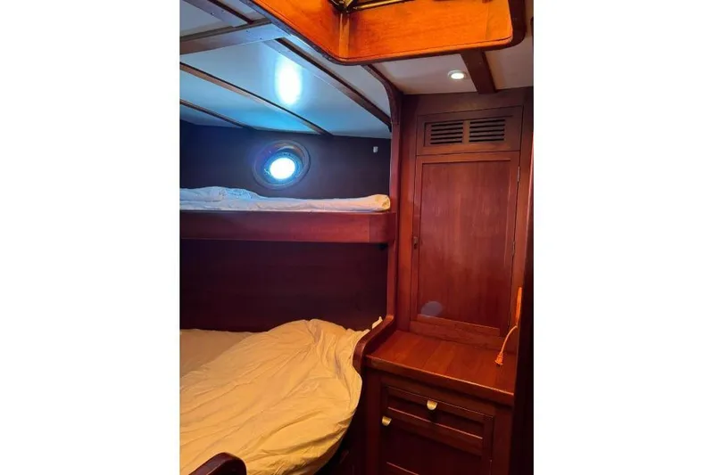  Yacht Photos Pics Cozy wooden cabin interior of 1987 Don Brooke 77 yacht with bunk beds and porthole.