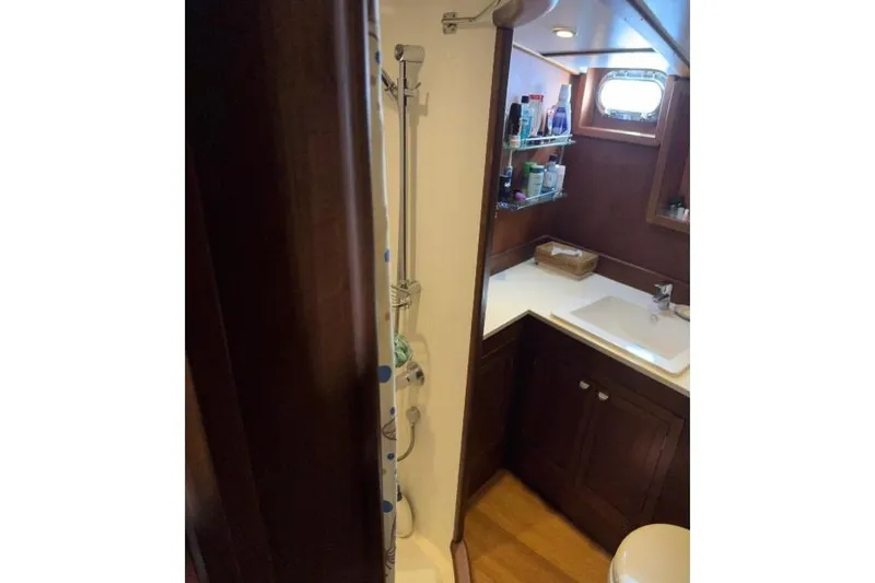  Yacht Photos Pics Compact bathroom in 1987 Don Brooke 77 yacht with shower, sink, and storage shelves.