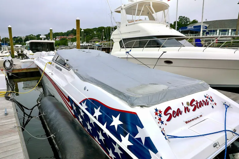  Yacht Photos Pics 2001 Fountain Lightning 42 speedboat docked, featuring star-spangled design and covered deck.