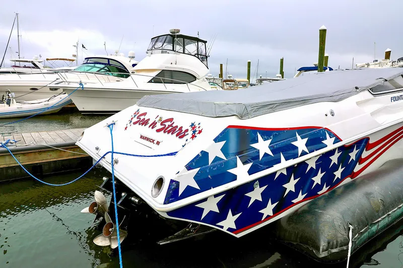  Yacht Photos Pics 2001 Fountain Lightning 42 speedboat with American flag design docked at marina.