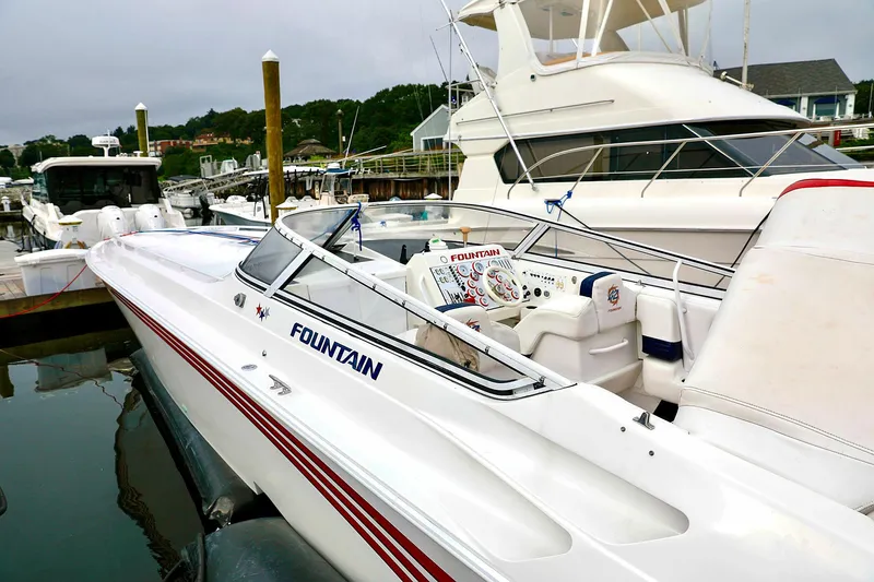  Yacht Photos Pics 2001 Fountain Lightning 42 speedboat docked at marina, sleek design, white with red accents.