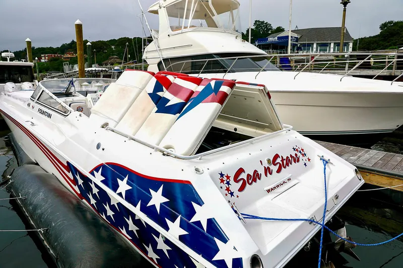  Yacht Photos Pics 2001 Fountain Lightning 42 speedboat with star-spangled design docked at marina.