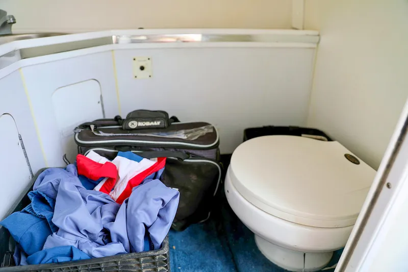  Yacht Photos Pics Boat bathroom interior with toilet, clothes basket, and bag; Fountain Lightning 42, 2001 model.