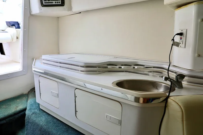  Yacht Photos Pics Interior of 2001 Fountain Lightning 42 boat with compact kitchenette and sink.