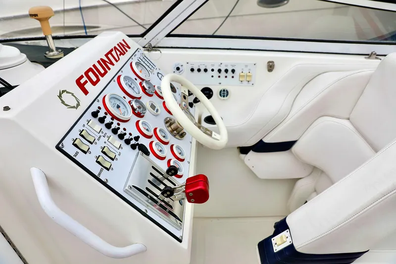  Yacht Photos Pics 2001 Fountain Lightning 42 boat cockpit with steering wheel and control panel.
